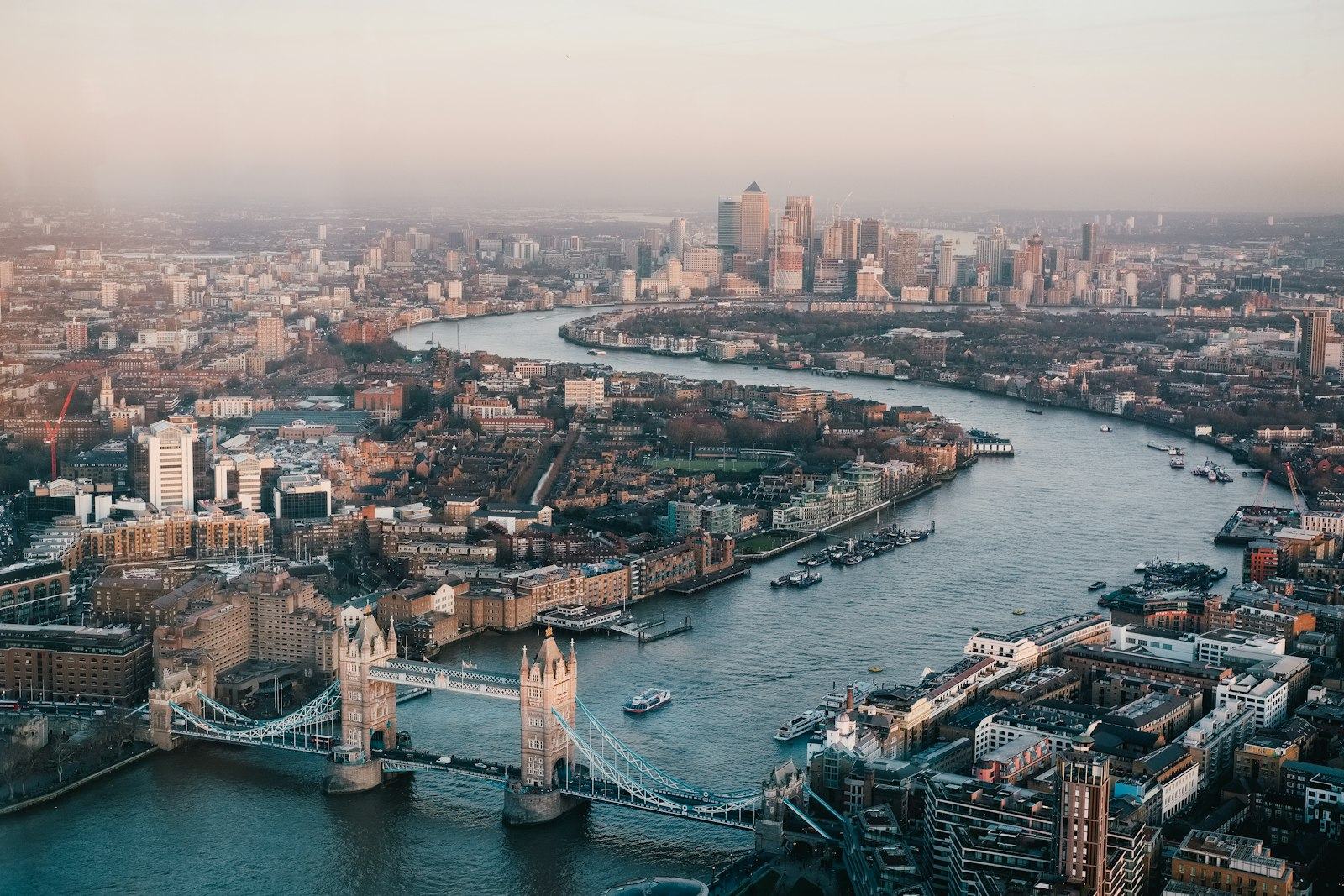 Aerial view of London along the River Thames, with Tower Bridge and the Canary Wharf financial district